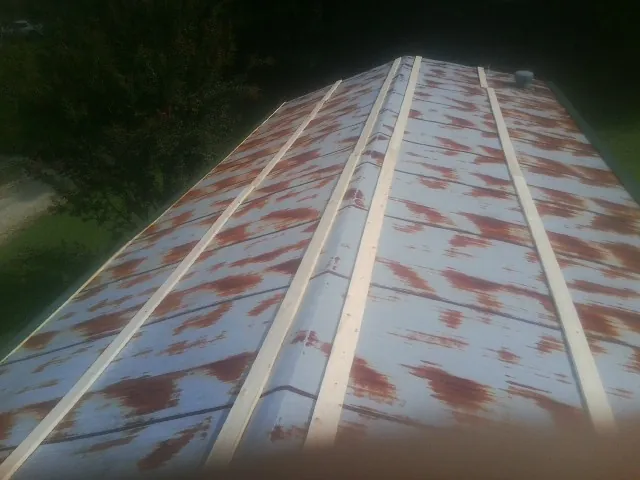 Rusted metal roof panels with new wood purlins before replacement — Storm Damage Roof Repair in Red Bank by Roofing Brothers