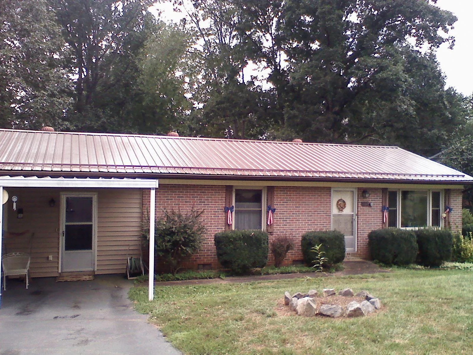 Bronze metal roof and carport on a brick ranch home — Roof Repair work by our crew in Red Bank